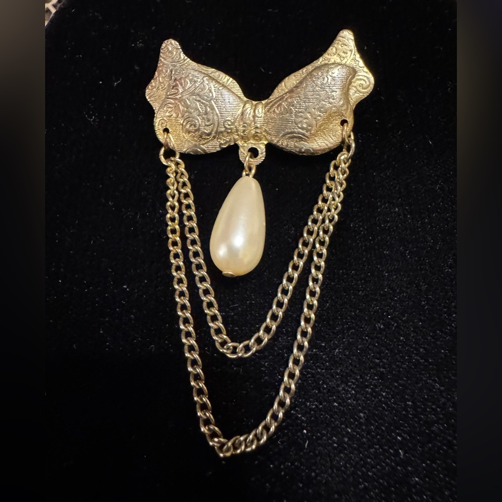 Sweet vintage champagne colored relief bow and faux drop pearl with chain brooch